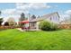Lush backyard features a patio with dining set and covered lounge area, surrounded by a well-maintained lawn and mature trees at 11205 Echo Ridge Ln, Indianapolis, IN 46236