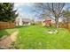 Green backyard offers ample space for recreation with a play set, lush lawn, and mature trees for privacy and shade at 11205 Echo Ridge Ln, Indianapolis, IN 46236