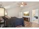 Comfortable bedroom featuring a ceiling fan, a large bed, and view into the ensuite bathroom at 11205 Echo Ridge Ln, Indianapolis, IN 46236