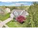 Aerial showcasing the property's manicured lawn, two-car garage, mature trees, and charming exterior at 11205 Echo Ridge Ln, Indianapolis, IN 46236