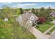 Aerial of a two-story home boasts a well-manicured lawn, lush trees, and a cozy front porch at 11205 Echo Ridge Ln, Indianapolis, IN 46236