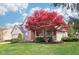 The exterior of the house features a vibrant red tree in the front yard, complemented by a brick facade and a cozy front porch at 11205 Echo Ridge Ln, Indianapolis, IN 46236