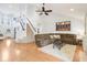 Comfortable living room featuring a plush sectional sofa, hardwood floors, and a staircase, perfect for relaxation and entertainment at 11205 Echo Ridge Ln, Indianapolis, IN 46236