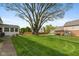 Well-manicured backyard with a large tree and a wooden fence at 11469 Burkwood Dr, Carmel, IN 46033