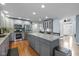 Spacious kitchen with gray cabinetry, large island, stainless steel appliances, and hardwood floors at 11469 Burkwood Dr, Carmel, IN 46033