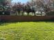 Backyard has a well-maintained lawn and a solid wooden privacy fence surrounded by mature trees at 11651 Congressional Ln, Indianapolis, IN 46235