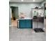 Kitchen area featuring stainless steel appliances, teal cabinets, and durable tile flooring at 11651 Congressional Ln, Indianapolis, IN 46235