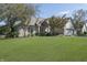 Traditional brick home featuring a lush green lawn, mature trees, and attached two car garage at 11697 Whisper Bay Ct, Carmel, IN 46033