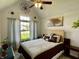 Bright bedroom with a queen bed, large window view, ceiling fan, and artistic wall decor at 12043 N Berling Dr, Mooresville, IN 46158