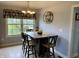 Sunlit dining area features a wooden table with seating for four, complemented by stylish decor and a large window at 12043 N Berling Dr, Mooresville, IN 46158