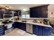 Beautiful kitchen featuring stylish blue cabinets, stainless steel appliances, and bright white countertops, a chef's dream at 12043 N Berling Dr, Mooresville, IN 46158