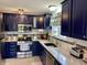 Beautiful kitchen featuring stylish blue cabinets, stainless steel appliances, and bright white countertops, a chef's dream at 12043 N Berling Dr, Mooresville, IN 46158