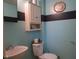 Powder room with painted accent stripe, white sink, toilet, cabinet, and vintage gold framed mirror at 121 Lake Hart, Mooresville, IN 46158