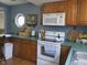 Charming kitchen showcasing wooden cabinets, white appliances, and functional countertops at 121 Lake Hart, Mooresville, IN 46158