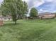 Expansive backyard with lush green lawn, mature trees, and a wooden deck, offering a private outdoor space at 1395 Heron Ridge Blvd, Greenwood, IN 46143