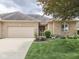 Charming brick home featuring an attached garage, manicured lawn, and lovely landscaping at 1395 Heron Ridge Blvd, Greenwood, IN 46143