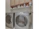 Laundry room with front load washer and dryer plus shelving and wire basket at 1395 Heron Ridge Blvd, Greenwood, IN 46143