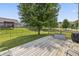 Lovely outdoor space with a wood deck, green grass, and mature trees providing shade and privacy at 15936 Symphony Blvd, Noblesville, IN 46060