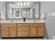 Bathroom featuring double sink vanity with wood cabinets, ample counter space, and a large mirror at 15936 Symphony Blvd, Noblesville, IN 46060