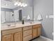 Bathroom featuring double sink vanity with wood cabinets, ample counter space, and a large mirror at 15936 Symphony Blvd, Noblesville, IN 46060