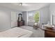 Bright bedroom featuring gray walls, carpet flooring, and a cozy rocking chair by the double windows at 15936 Symphony Blvd, Noblesville, IN 46060