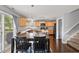 Bright dining area with a dark wood table set, adjacent to a modern kitchen and staircase at 15936 Symphony Blvd, Noblesville, IN 46060