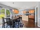 Open-concept dining area with wood floors, adjacent to a well-equipped kitchen and a backyard view at 15936 Symphony Blvd, Noblesville, IN 46060