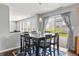 Dining room area features a dark wood table, seating for six, view of backyard, and blue patterned rug at 15936 Symphony Blvd, Noblesville, IN 46060