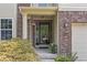 Charming front entryway with a decorative door, brick accents, lush greenery, and a well-maintained lawn at 15936 Symphony Blvd, Noblesville, IN 46060