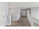 Hallway featuring carpet flooring, neutral paint, and white banisters leading to the upper level at 15936 Symphony Blvd, Noblesville, IN 46060