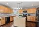 Modern kitchen with hardwood floors, light wood cabinets, updated appliances and center island at 15936 Symphony Blvd, Noblesville, IN 46060