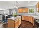 Bright kitchen & dining area featuring wood cabinets, center island, and sliding glass doors to backyard at 15936 Symphony Blvd, Noblesville, IN 46060
