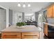 Bright kitchen with a large island, wooden cabinets, stainless steel dishwasher, and sliding glass doors at 15936 Symphony Blvd, Noblesville, IN 46060