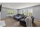 Living room features neutral walls, soft carpeting, multiple windows, and comfortable seating at 15936 Symphony Blvd, Noblesville, IN 46060