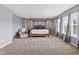Main bedroom features a four-poster bed, soft carpet, chair, two windows, and neutral walls at 15936 Symphony Blvd, Noblesville, IN 46060