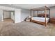 Spacious main bedroom with a four poster bed, chair, soft carpet, and connecting bathroom at 15936 Symphony Blvd, Noblesville, IN 46060
