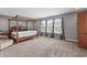 Main bedroom features a four-poster bed, soft carpet, neutral walls, and two windows at 15936 Symphony Blvd, Noblesville, IN 46060