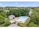 Community pool surrounded by mature trees and a glimpse of the neighborhood at 15936 Symphony Blvd, Noblesville, IN 46060