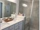 Bathroom featuring double sinks, quartz counters, tiled shower with glass door and bench at 17364 Graley Pl, Westfield, IN 46074