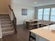 A dining room with a staircase, a table with bench seating, and three large windows at 17364 Graley Pl, Westfield, IN 46074