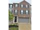 A three-story brick townhouse featuring black shutters, gray siding, and a gray garage door at 17364 Graley Pl, Westfield, IN 46074