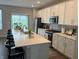 A modern kitchen featuring white cabinets, stainless steel appliances, and a large island with bar seating at 17364 Graley Pl, Westfield, IN 46074