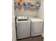 Bright laundry room featuring a modern Samsung washer and dryer set with shelf storage above at 17364 Graley Pl, Westfield, IN 46074