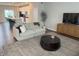 A large living room leading to the kitchen, featuring a sofa, area rug, and media console at 17364 Graley Pl, Westfield, IN 46074