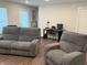 Cozy living room with reclining sofa and chair, a desk area and wood-look floors at 17364 Graley Pl, Westfield, IN 46074