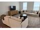 An open living room with a large neutral sofa, a dark wood coffee table, and a woven media console at 17364 Graley Pl, Westfield, IN 46074