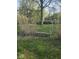 Metal swing in backyard with mature trees and tall grass at 1817 Sparrow Ave, Indianapolis, IN 46227