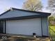 Attached garage with a large white door, providing ample space for parking and storage at 1817 Sparrow Ave, Indianapolis, IN 46227