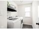 Clean and functional laundry room with modern washer and dryer and ample shelving at 214 Handley St, Indianapolis, IN 46222