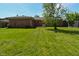 Brick home exterior with green grass and mature trees at 2220 Radcliffe Ave, Indianapolis, IN 46227